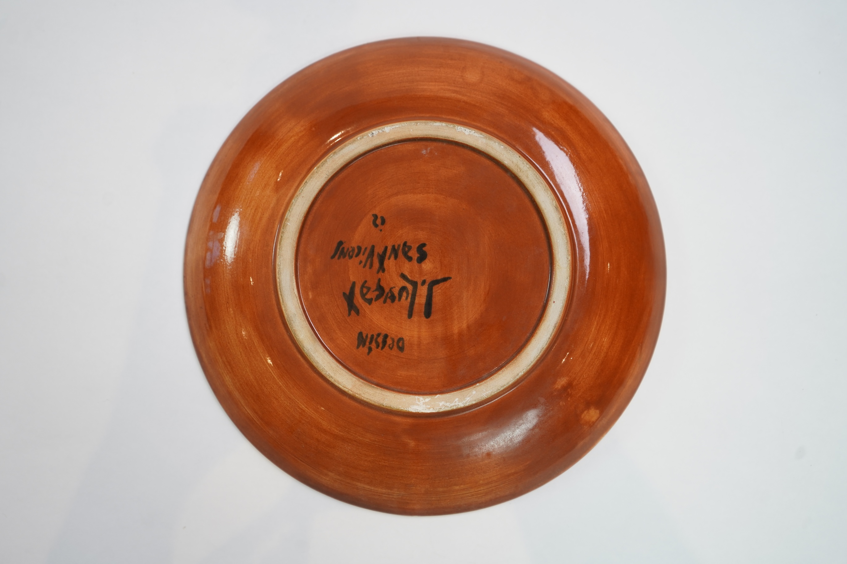 Jean Lurçat (1892-1966): A rust glazed earthenware plate, decorated with a stylised central figure